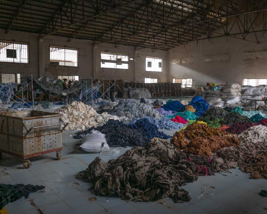 Factory with a lot of discarded fabric showing the mass production of fast fashion.
